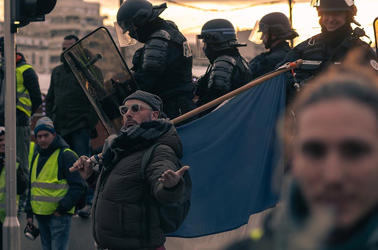 Manifestant tenant un drapeau face aux CRS, gilets jaunes Marseille — PUShAUNE photographe