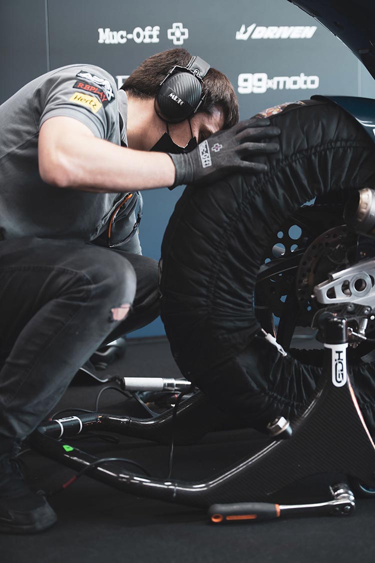 Mécanicien équipant la roue arrière d'une moto de course en paddock — PUShAUNE photographe
